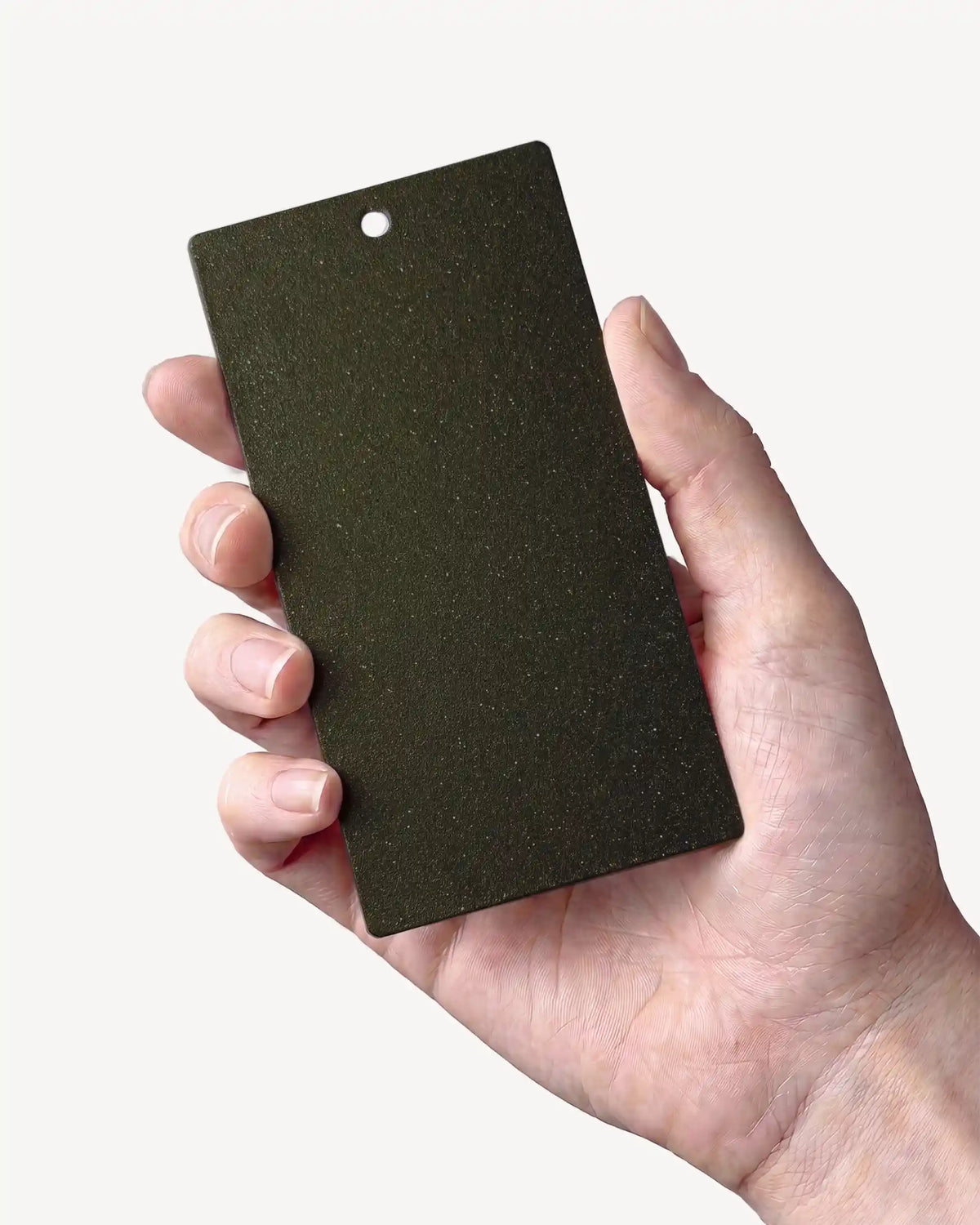 Hand die een staaltje in de kleur Olijfgroen PILOTIS vasthoudt