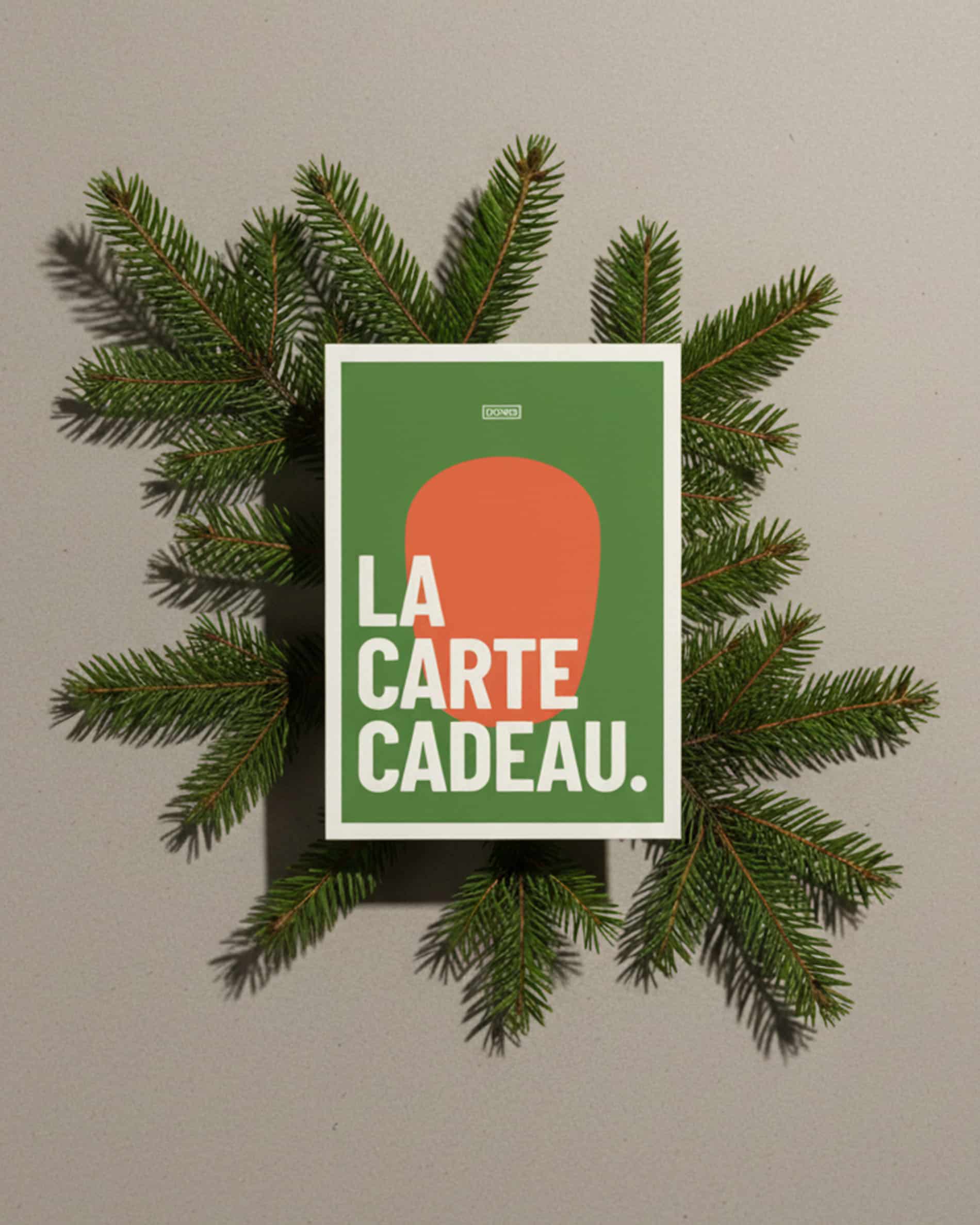 Kokko cadeaubon afgebeeld op een decoratieve achtergrond met dennentakken, grafisch ontwerp in groen en oranje.