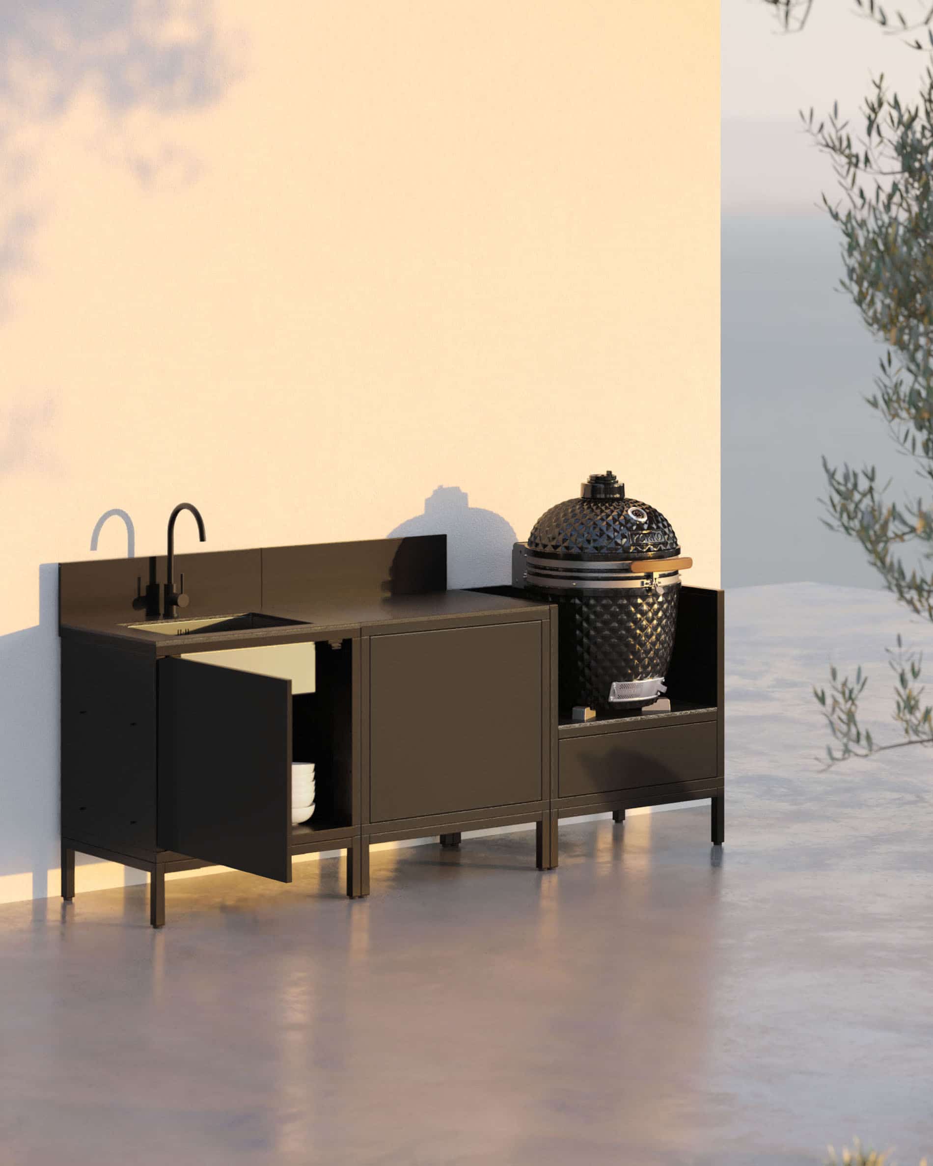 Buitenkeuken op palen met 3 modules voor kamado, geïntegreerde spoelbak, zwart meubel met bijpassend werkblad en achterwand, spoelbak met kraan links, centraal afsluitbare opbergruimte en geïntegreerde kamado in het rechter zijmodule, constructie op zwarte poten, geschikt voor buitengebruik.
