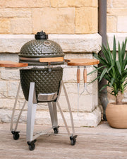 Kamado Kokko L 18 inch in olijfgroene keramiek, geplaatst op een onderstel.
