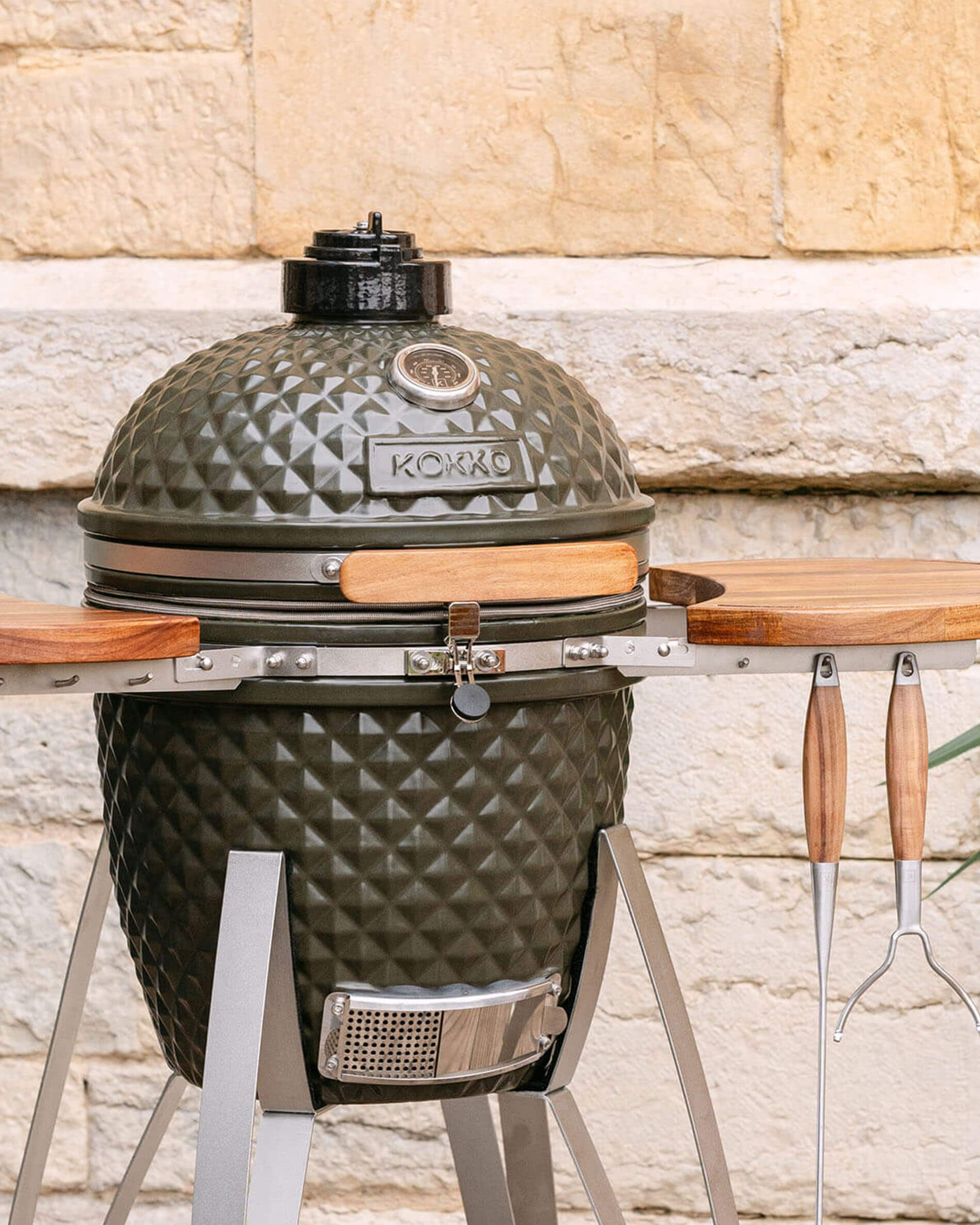 Kokko kamado-barbecue 18 inch in olijfgroene kleur, solo gepresenteerd in de buitenlucht.