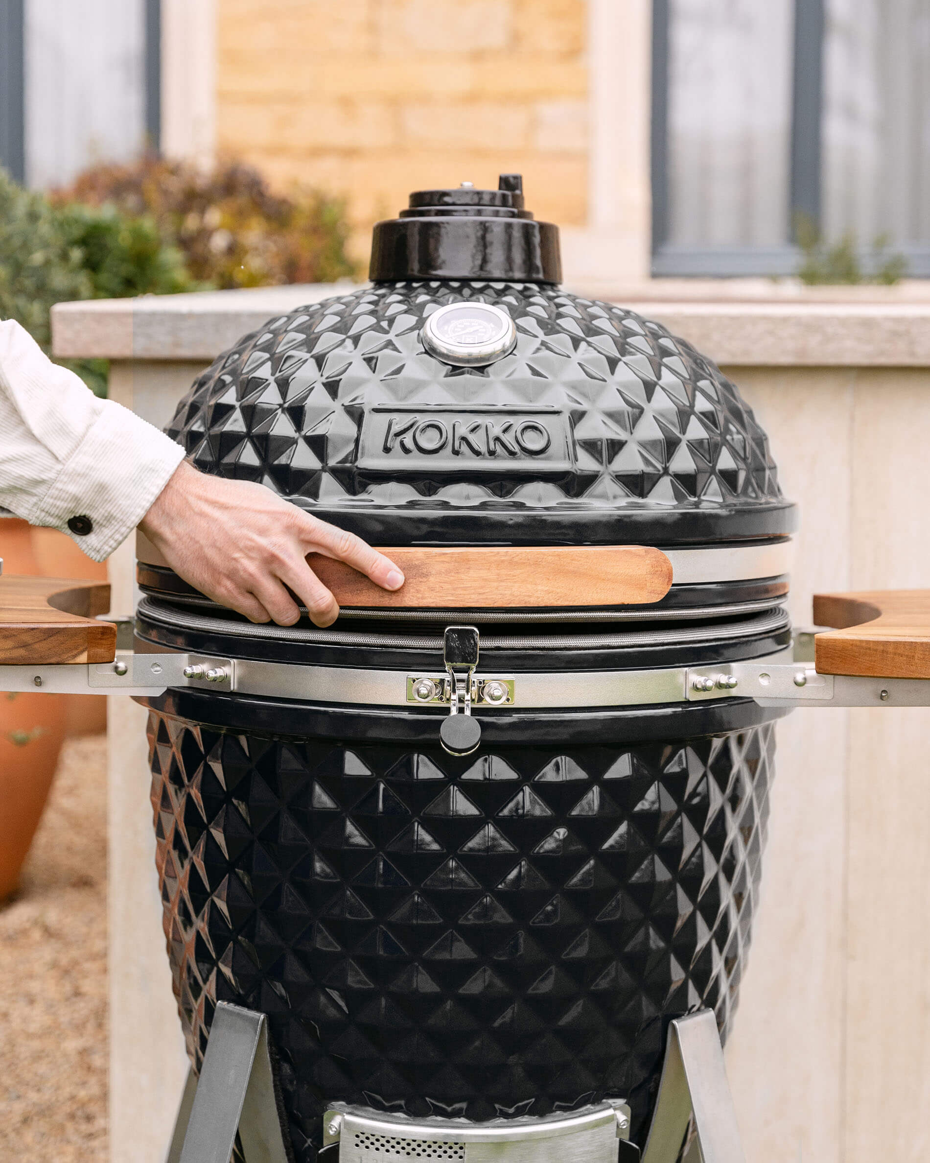 Kamado Kokko XL 22 inch in zwarte keramiek, geplaatst buiten.