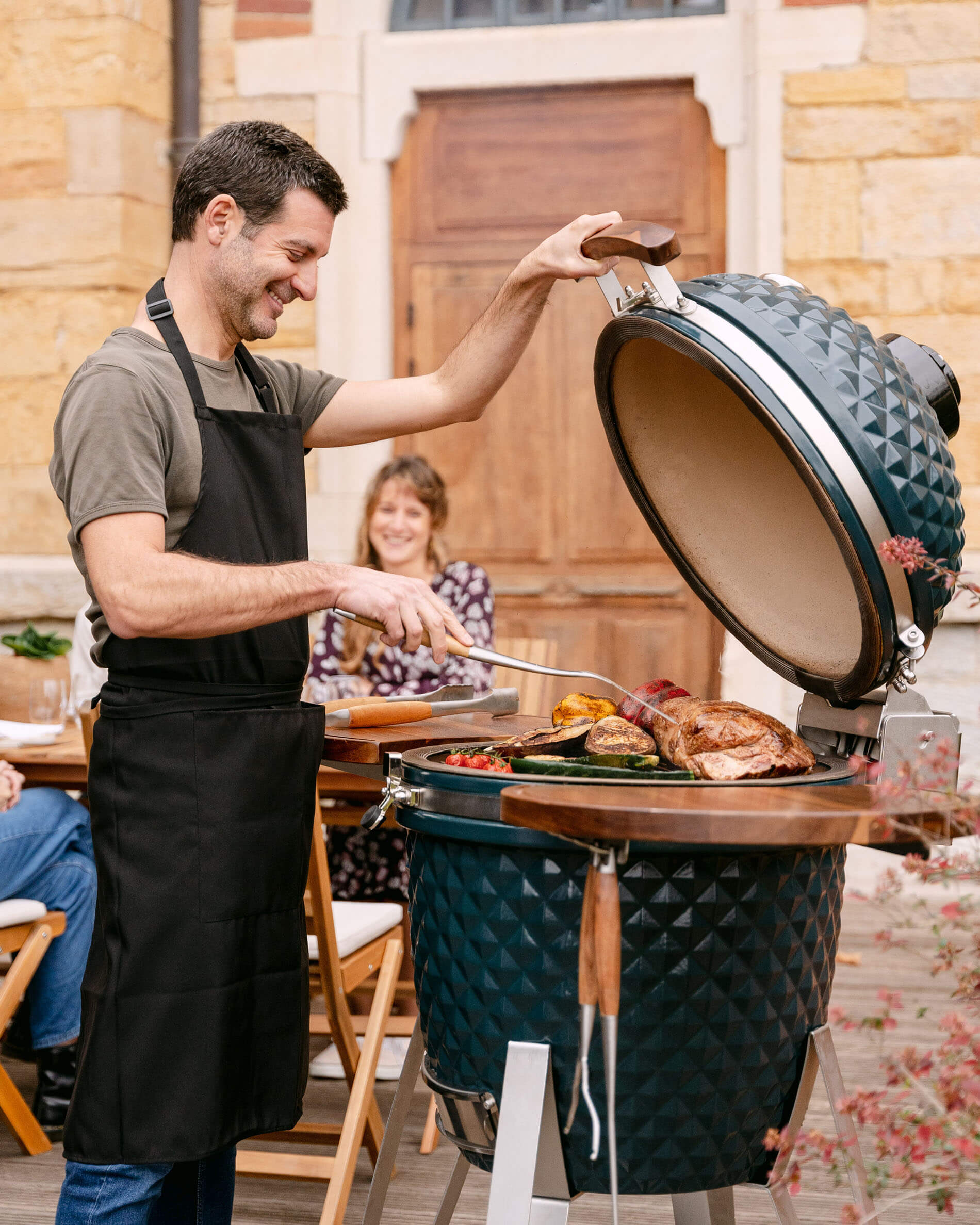 Kamado Kokko XL 22 inch keramisch in oceaanblauw tijdens gebruik.