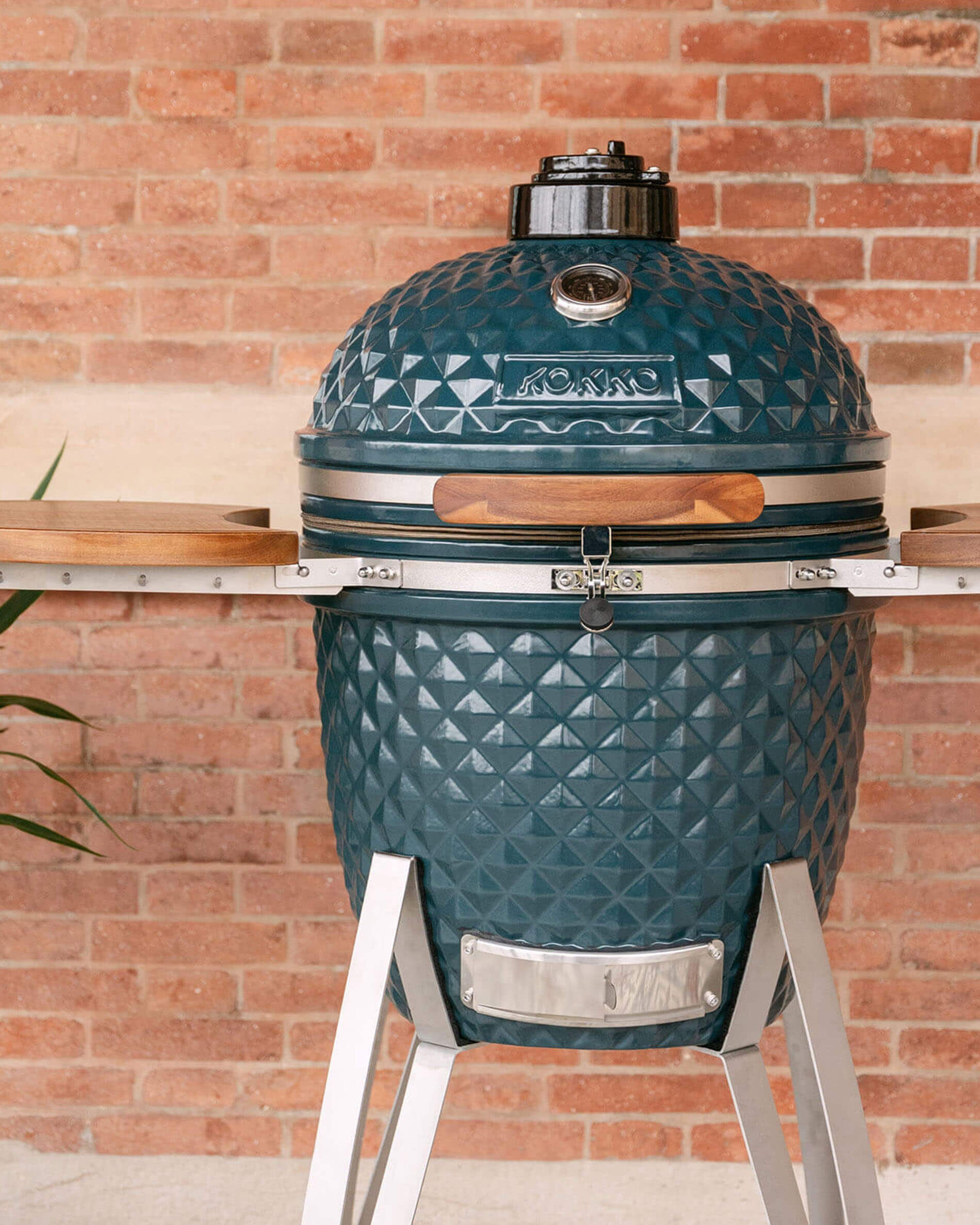 Kokko kamado-barbecue 22 inch in oceaankleur, solo gepresenteerd in de buitenlucht.