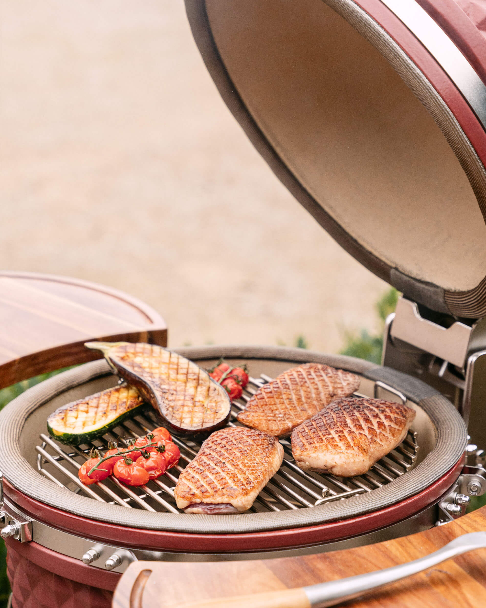 Kamado Kokko L 18 inch tijdens het grillen met vlees en groenten op het rooster.