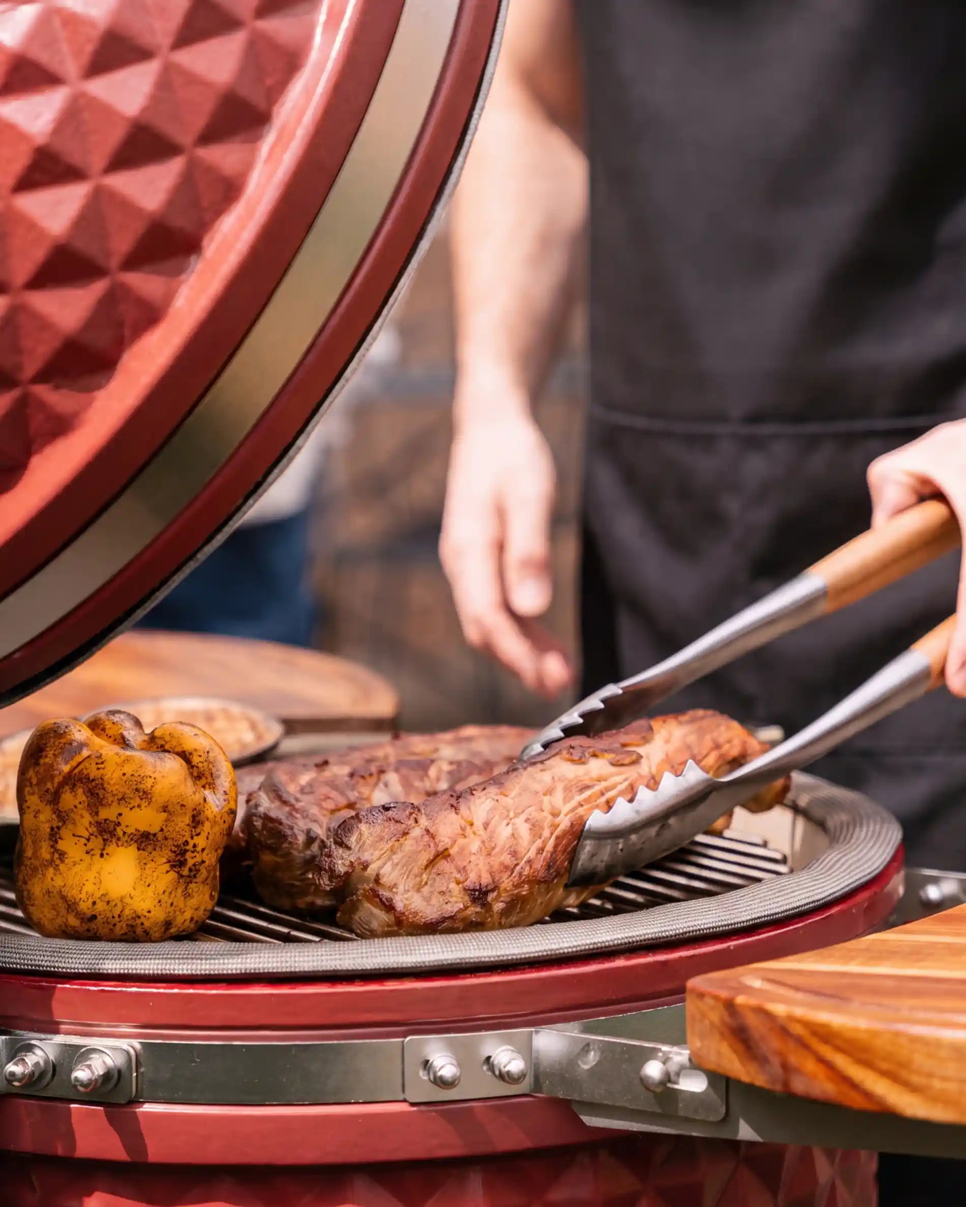 Pince du set Kokko utilisée sur un kamado