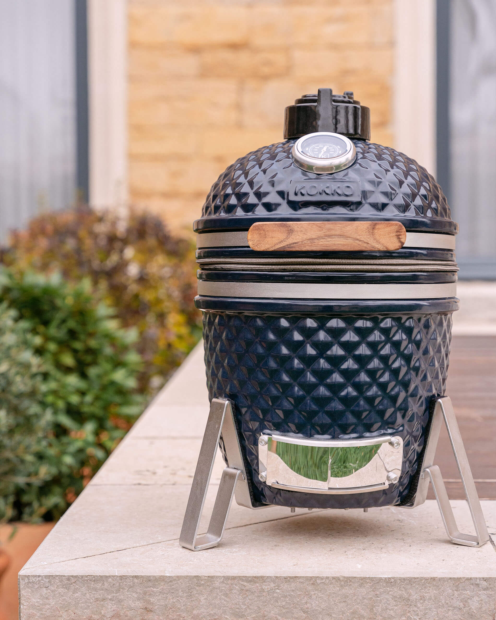Kamado Little Kokko 13 van keramiek in marineblauw, geplaatst op zijn onderstel.