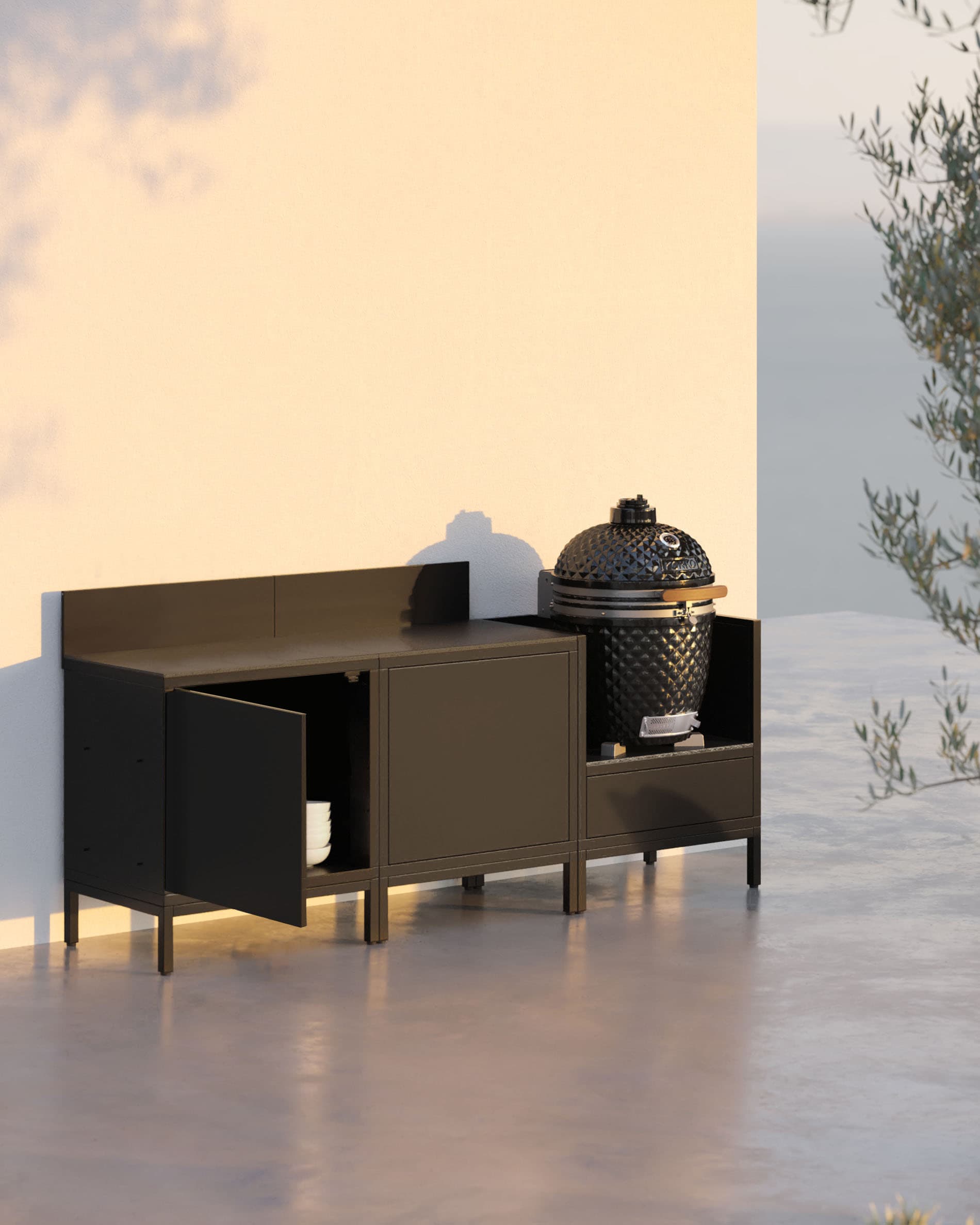 Buitenkeuken op palen met 3 modules, kamado, zwart meubel en een open opbergdeur.