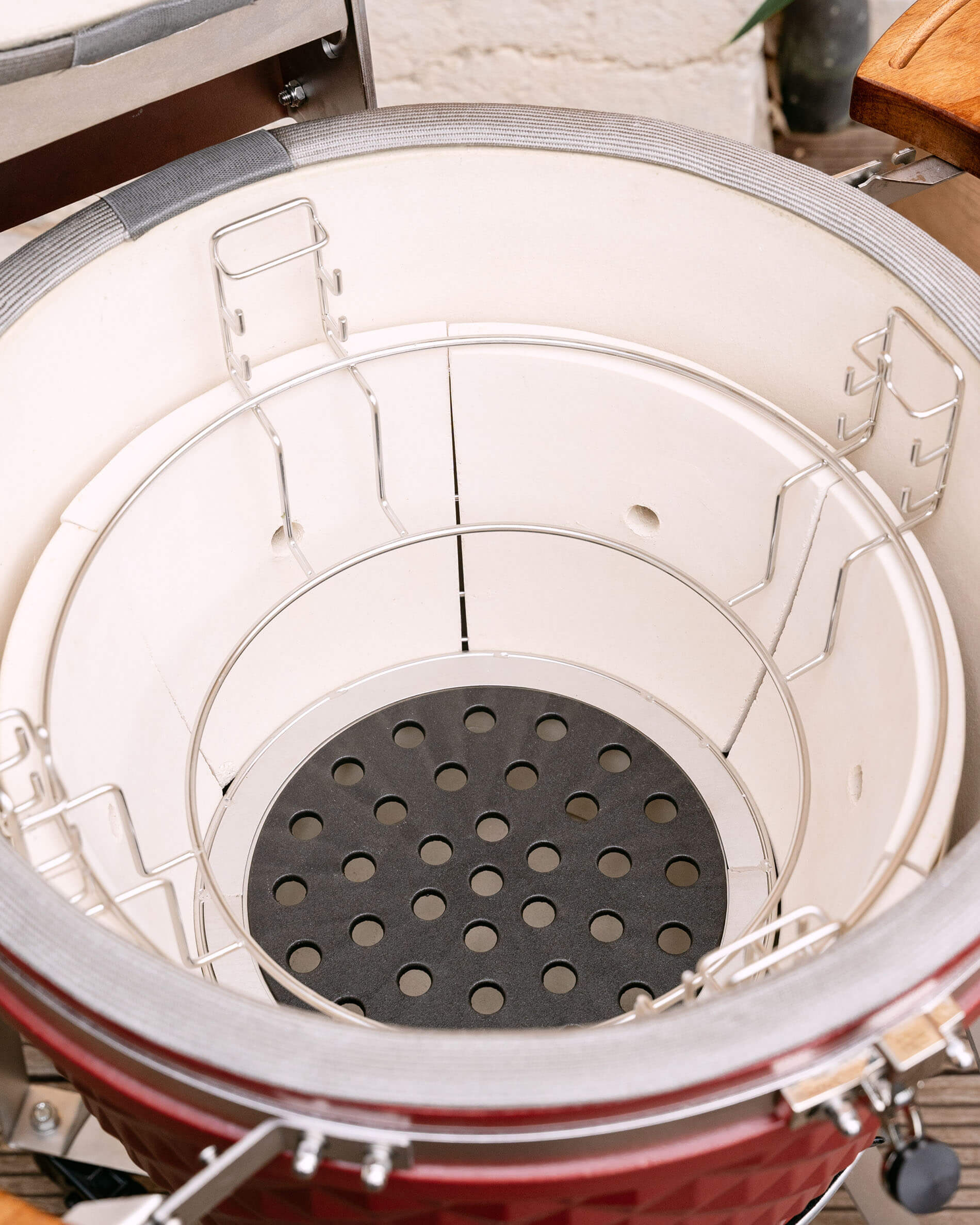 Geperforeerde gietijzeren plaat voor lucht- en houtskoolcirculatie in de kamado.