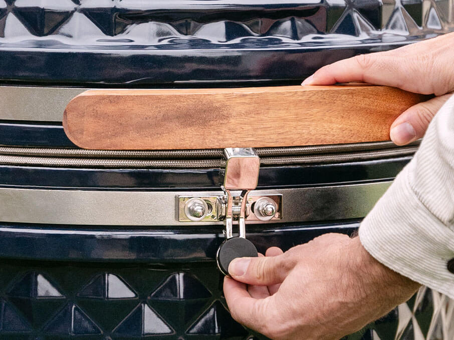 Close-up van de veiligheidssluiting van de nieuwe editie Kokko kamado, die het deksel stevig op zijn plaats houdt bij het openen en sluiten.